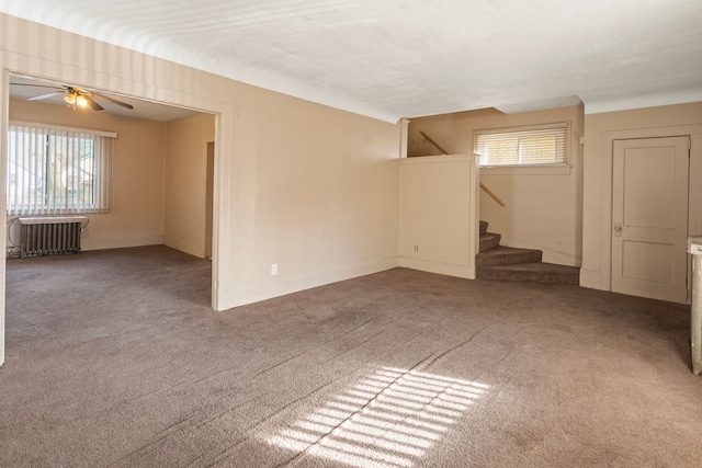 unfurnished room with radiator, stairs, a ceiling fan, and carpet floors