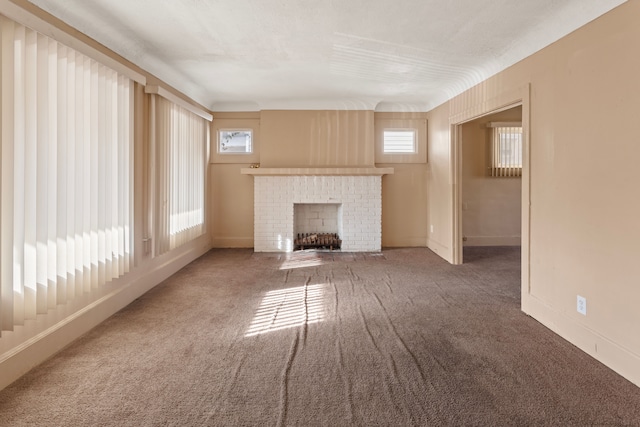 unfurnished living room featuring carpet flooring, a fireplace, and baseboards