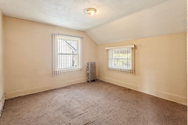 bonus room featuring carpet, baseboards, radiator heating unit, vaulted ceiling, and a textured ceiling