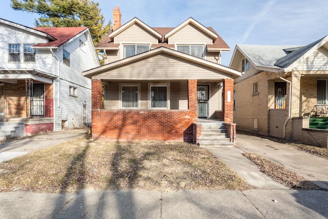 view of front facade featuring brick siding and a porch