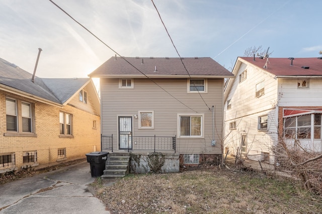 back of property with roof with shingles