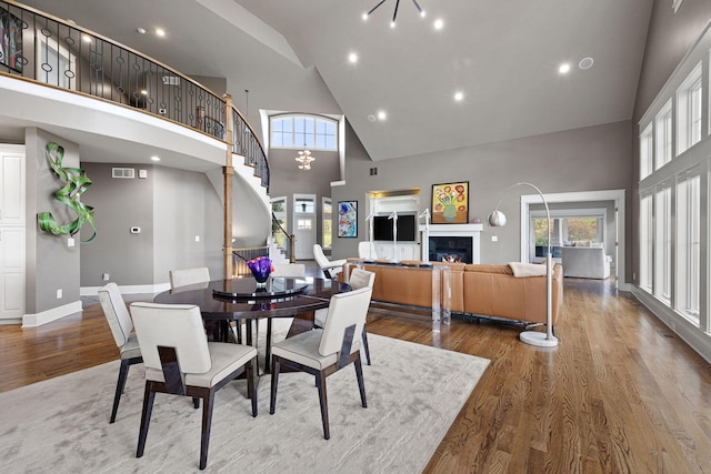 565 Golden Bear Ct, Saint Joseph, MI 49085 - dining space with stairs, plenty of natural light, a lit fireplace, and wood finished floors