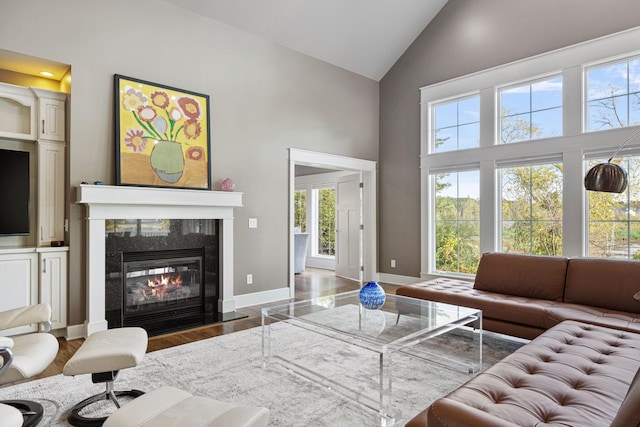 565 Golden Bear Ct, Saint Joseph, MI 49085 - living area featuring high vaulted ceiling, wood finished floors, a tile fireplace, and baseboards