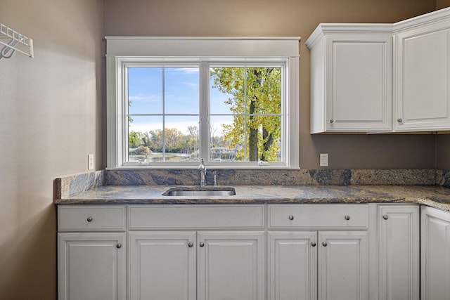 565 Golden Bear Ct, Saint Joseph, MI 49085 - kitchen featuring a wealth of natural light, dark stone countertops, a sink, and white cabinetry