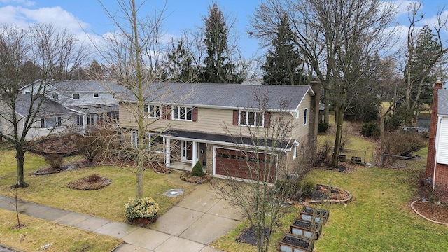 traditional home featuring a front yard, driveway, an attached garage, and fence