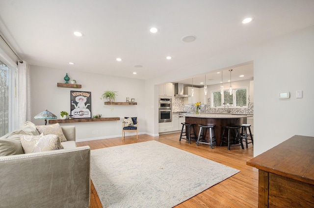 living area with recessed lighting, plenty of natural light, and light wood finished floors