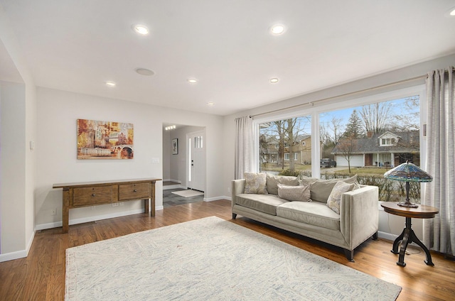 living room with recessed lighting, baseboards, and wood finished floors