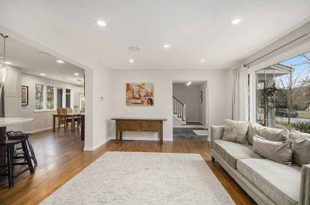 living area with dark wood-type flooring, recessed lighting, stairway, and baseboards