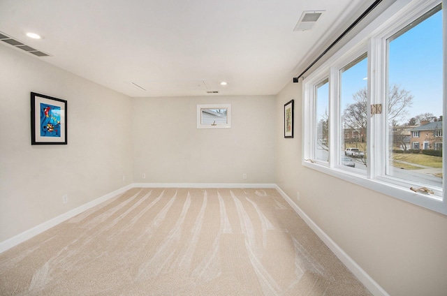 spare room with light carpet, recessed lighting, visible vents, and baseboards