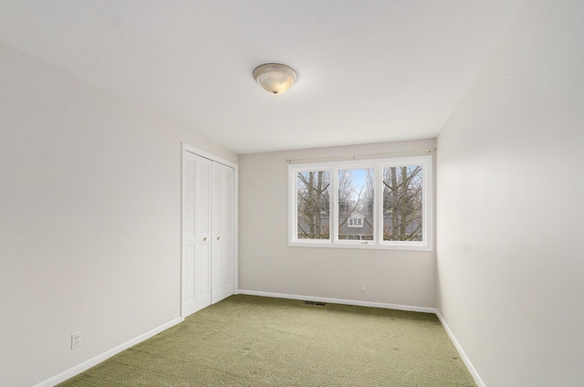 unfurnished bedroom with carpet floors, a closet, visible vents, and baseboards