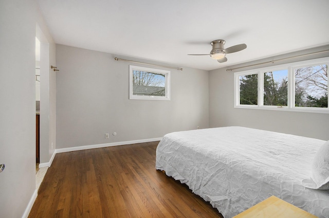 bedroom with multiple windows, ceiling fan, baseboards, and wood finished floors