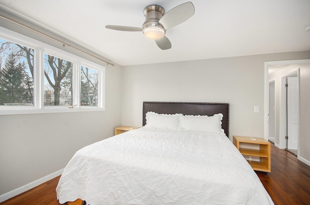 bedroom with a ceiling fan, baseboards, and wood finished floors