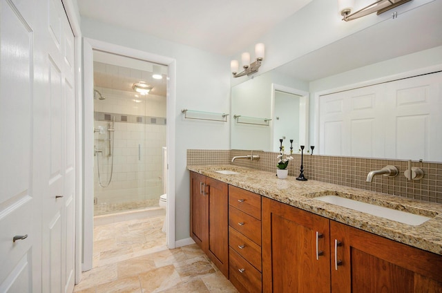 full bath with a stall shower, backsplash, and a sink