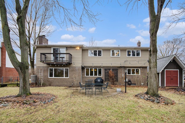 back of property featuring brick siding, a chimney, and a balcony