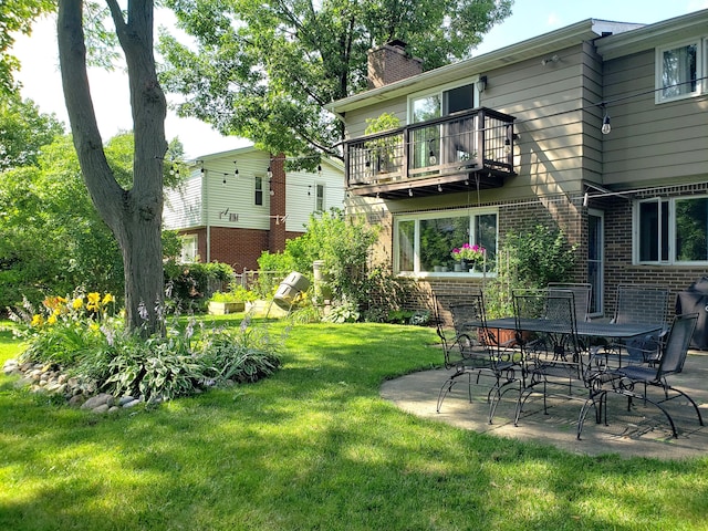 view of yard featuring a balcony and a patio area