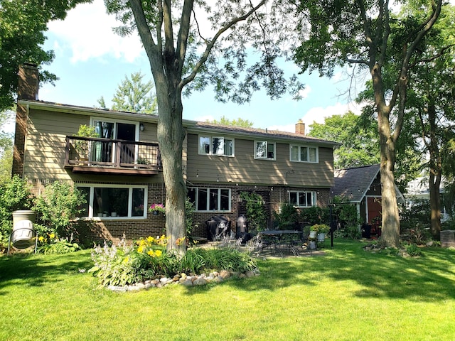 view of front of house featuring a chimney, a front lawn, and brick siding