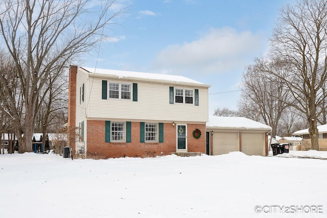 colonial inspired home featuring brick siding, an attached garage, and central air condition unit