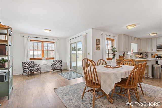 dining room featuring light wood-style floors and baseboards