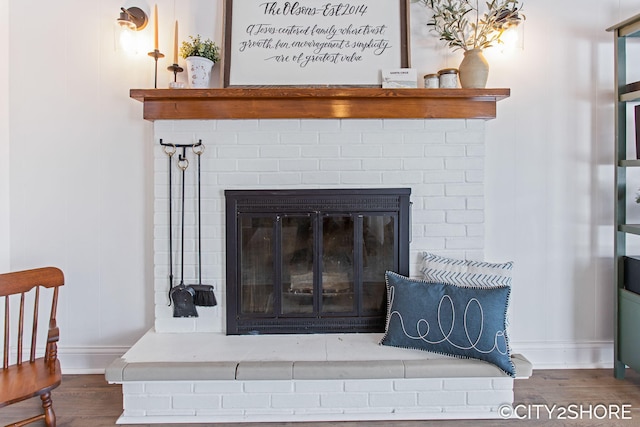 details with a fireplace, baseboards, and wood finished floors