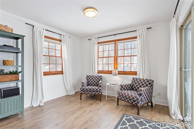 living area with light wood-style flooring and baseboards