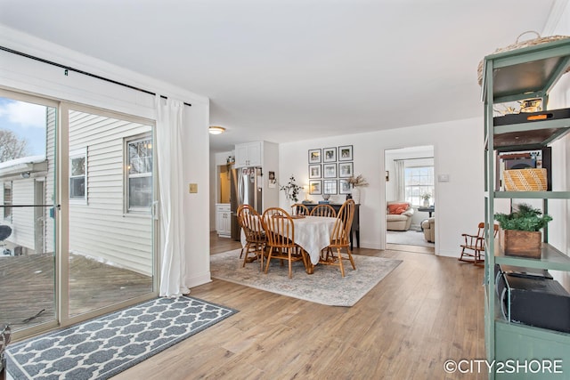 dining space with light wood finished floors and baseboards