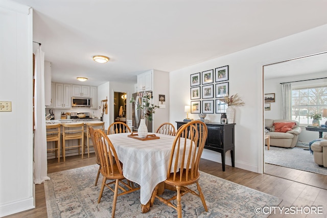 dining room featuring baseboards and light wood finished floors