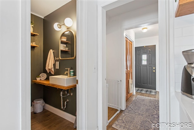 bathroom with baseboards, a sink, and wood finished floors