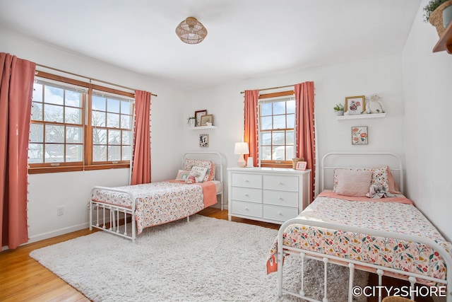 bedroom featuring baseboards and wood finished floors