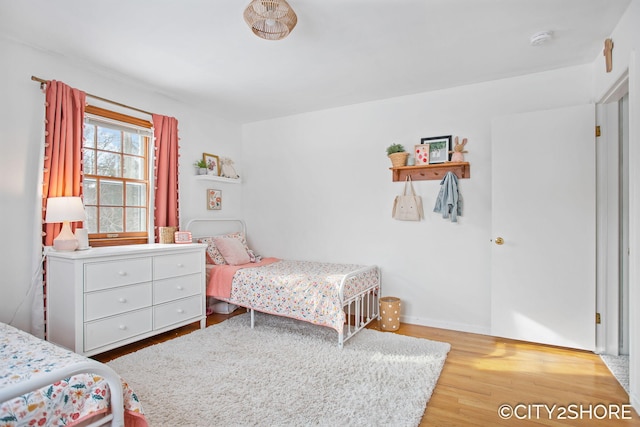 bedroom with wood finished floors and baseboards