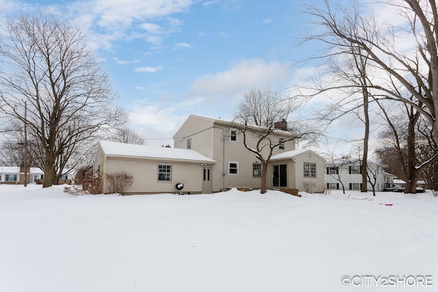 snow covered property featuring a chimney