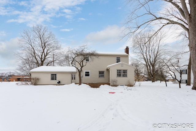 snow covered house with a chimney