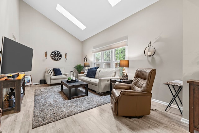 living area featuring a skylight, baseboards, high vaulted ceiling, and wood finished floors