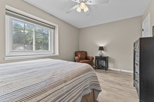 bedroom with light wood-style flooring, baseboards, and ceiling fan