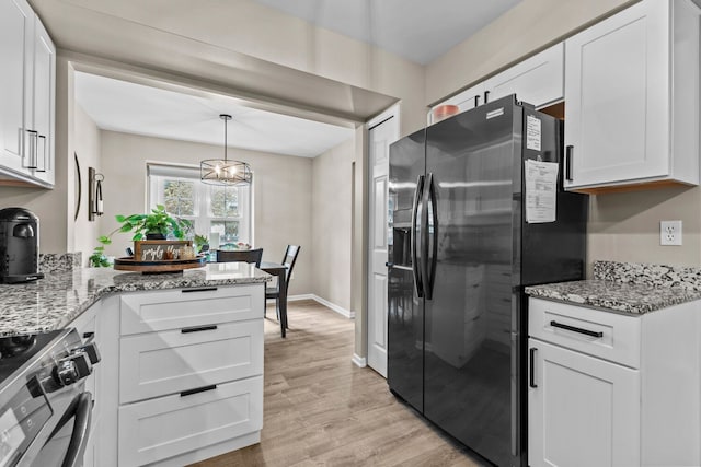 kitchen featuring light stone counters, light wood-style flooring, white cabinetry, fridge with ice dispenser, and stainless steel electric range oven