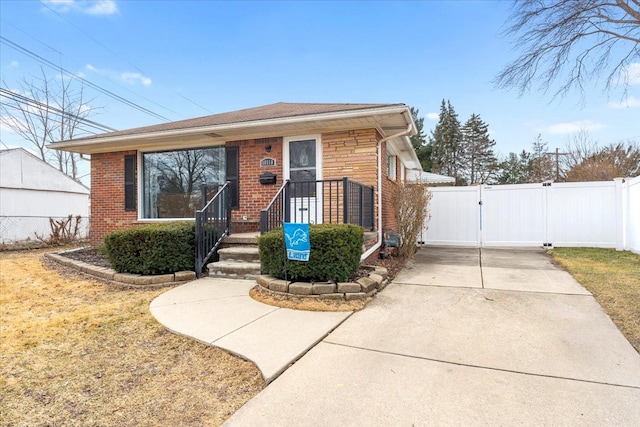 bungalow-style house featuring brick siding, fence, and a gate