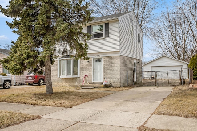 view of front of home featuring brick siding, a garage, an outdoor structure, and fence