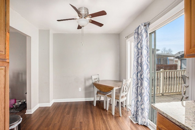 dining room featuring baseboards, wood finished floors, and a ceiling fan