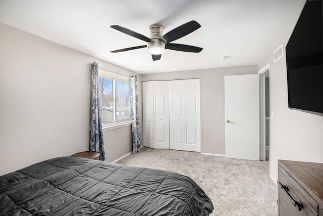 bedroom with a ceiling fan, visible vents, baseboards, a closet, and light colored carpet