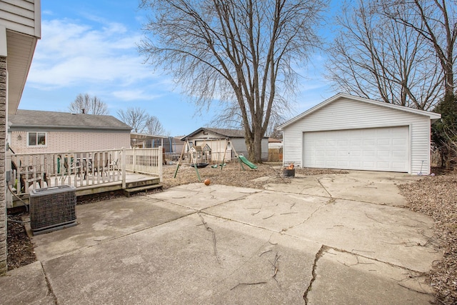 exterior space with an outbuilding, a detached garage, a playground, cooling unit, and a wooden deck