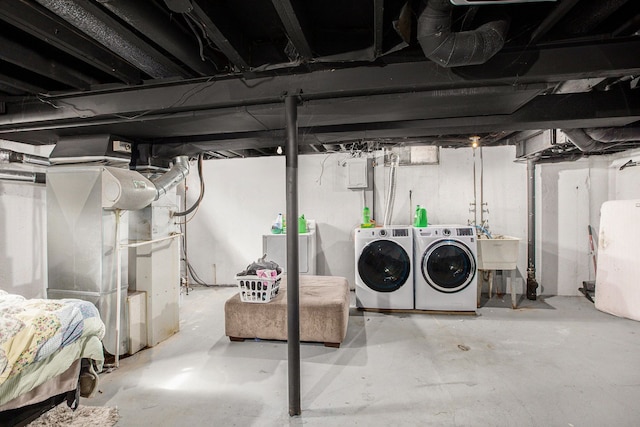 unfinished below grade area featuring washing machine and clothes dryer and a sink