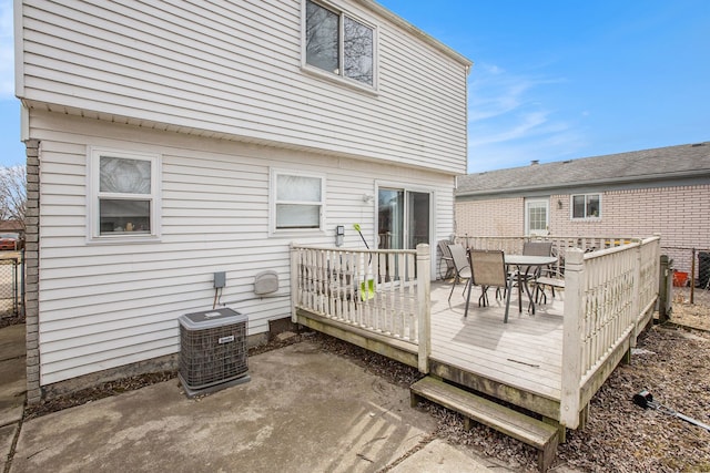 deck featuring outdoor dining area and central AC unit