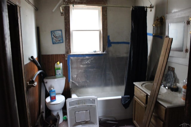 full bathroom with a wainscoted wall, heating unit, toilet, shower / bath combo, and vanity