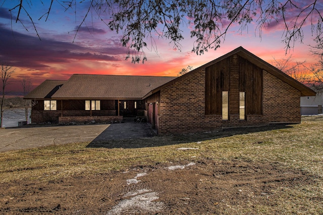 mid-century home with brick siding and a yard