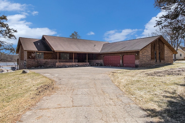 view of front of house with brick siding, an attached garage, and driveway