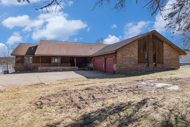 back of house featuring brick siding and an attached garage