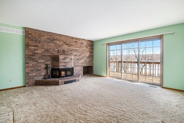 unfurnished living room featuring visible vents, a brick fireplace, baseboards, and carpet