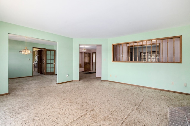 carpeted spare room featuring baseboards