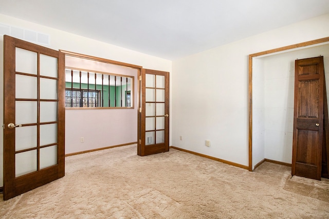 carpeted spare room with visible vents, french doors, and baseboards