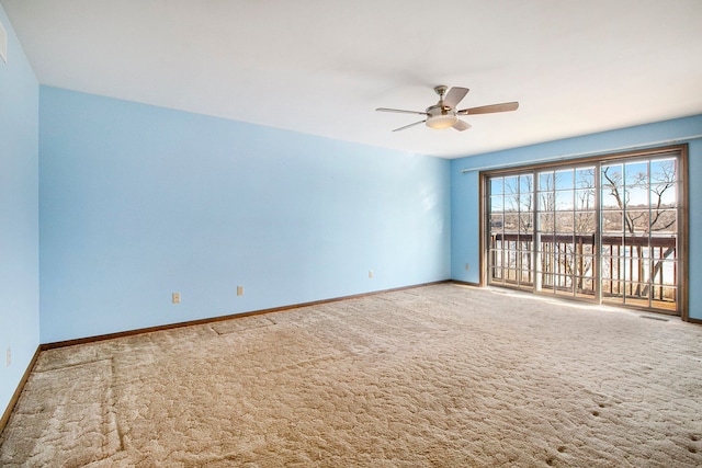 carpeted spare room featuring a ceiling fan, visible vents, and baseboards