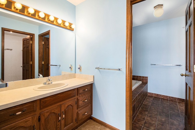 full bathroom with tile patterned floors, baseboards, a tub to relax in, and vanity